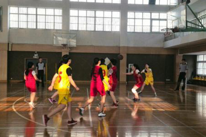 校区体育馆内打篮球的学生
