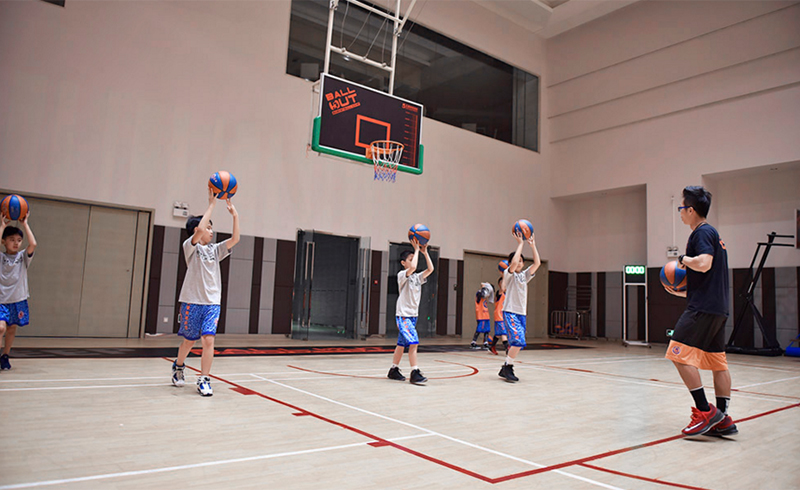 北京五星体育运动，老师指导学生练习投篮姿势。