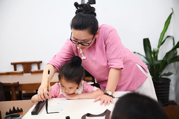 老师指导学员练习书法