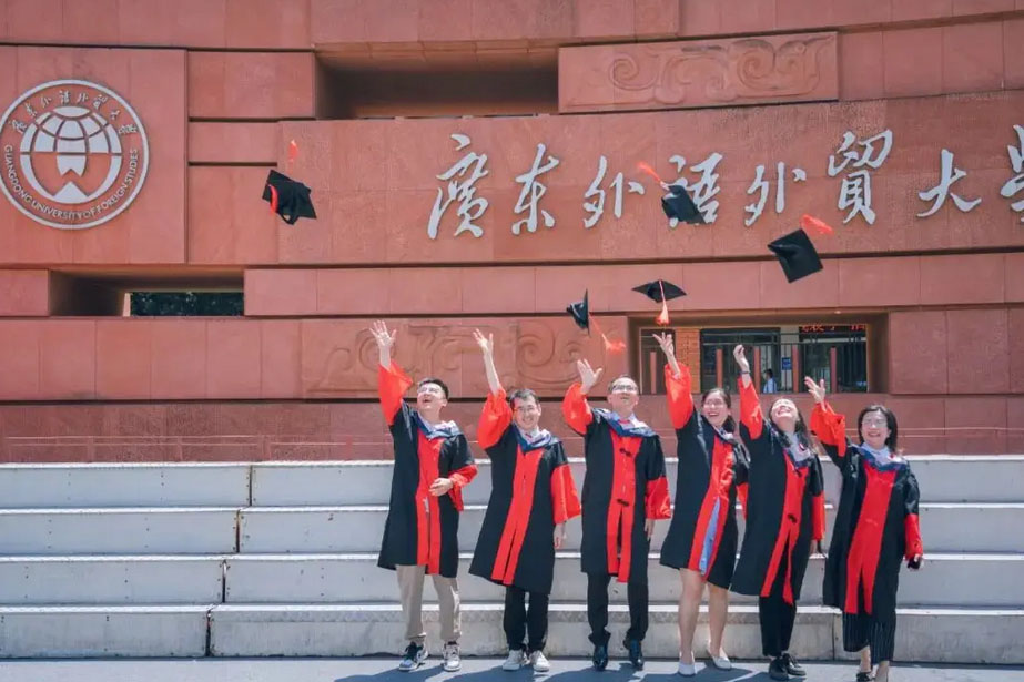 广东外语外贸大学国际学院毕业生在校门前拍照留念